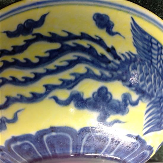 A Chinese yellow ground dragon and phoenix bowl, Xuande six character mark and possibly of the period, 19.5cm, museum restoration, sc